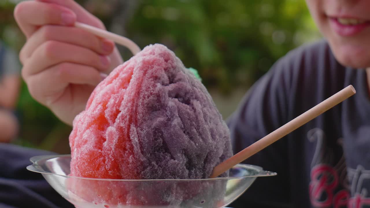 кавказский мальчик ест разноцветный лед для бритья