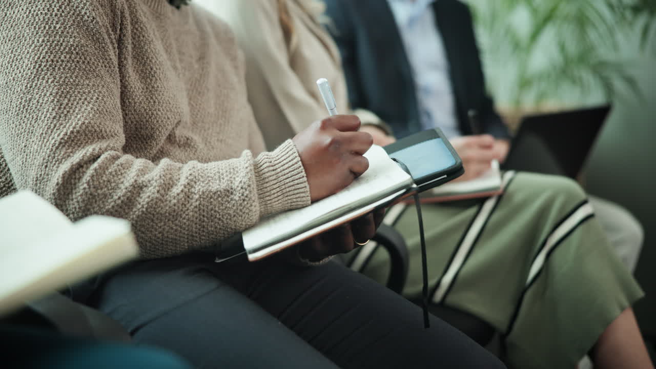 People taking notes during a meeting