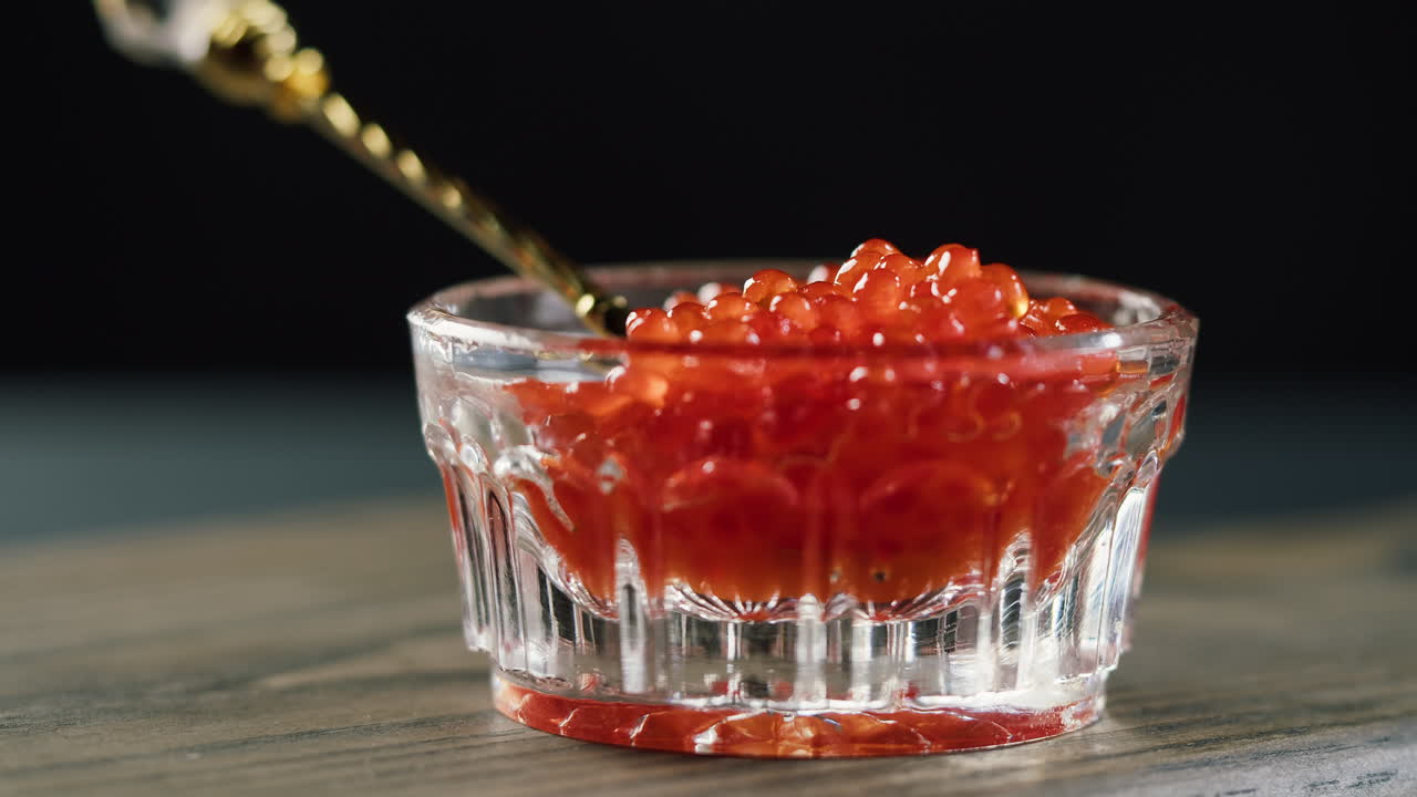 Servindo Caviar Vermelho em uma Pequena Tigela de Vidro com uma Colher