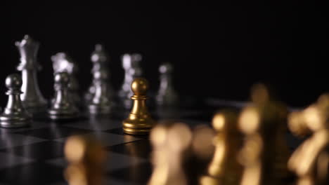 Cinematic-focus-shot-of-chess-pieces-on-a-chess-board,-front-view-of-white-figure-and-other-line-of-yellow-figures-blurred-in-front-of-them