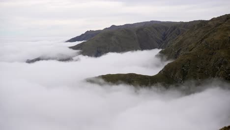 time-lapse of a blanket of clouds forming beneath mountain peaks