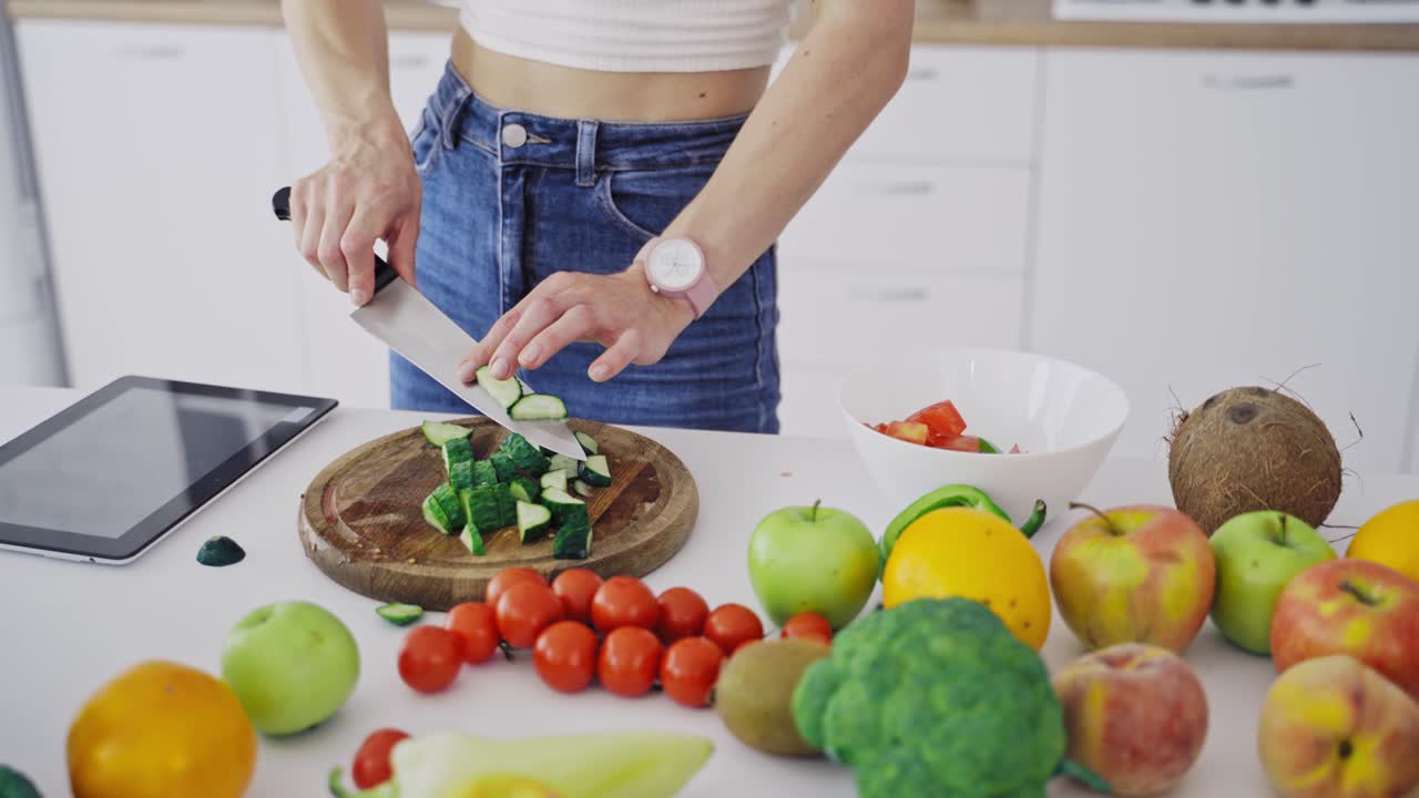 Cooking woman in kitchen. Young woman cooking salad with fresh vegetables in kitchen interior at home