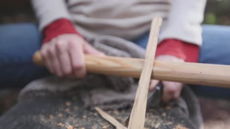 carefully splitting wood with knife