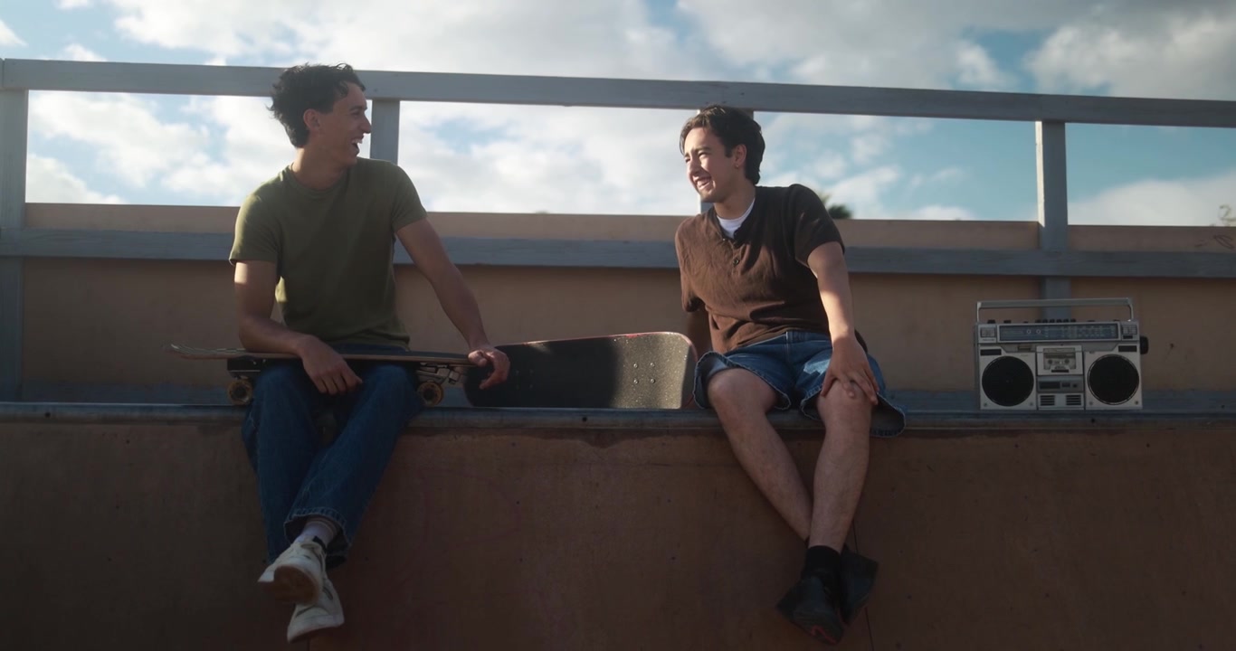 Two Young Men Laughing and Talking at a Skatepark