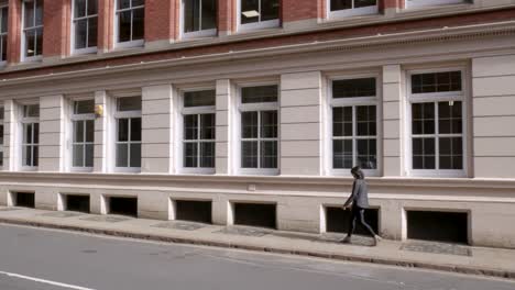 attractive woman walks along the opposite side of the street