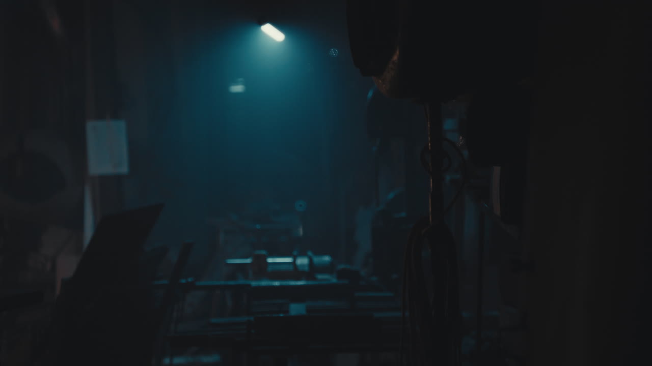 Mysterious man in the workshop at night smokes a cigarette