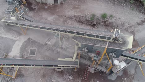 Industrial-machine-pulverizing-rock-into-different-types-of-gravel-and-sand-in-a-quarry---Aerial-view