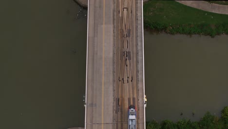 Birds-eye-view-of-a-Metro-rail-train-car-going-over-bayou-on-bridge