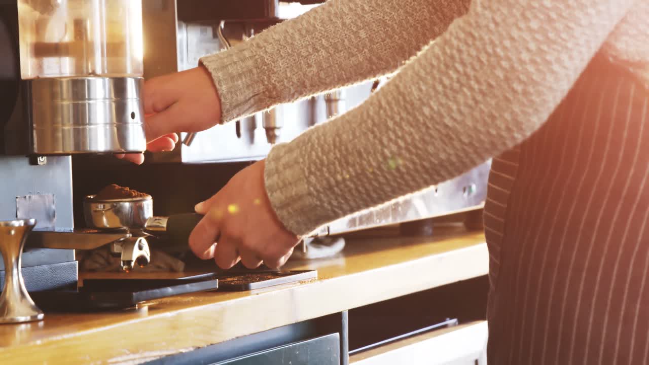 Cameriere che usa il macinacaffè per macinare i chicchi di caffè