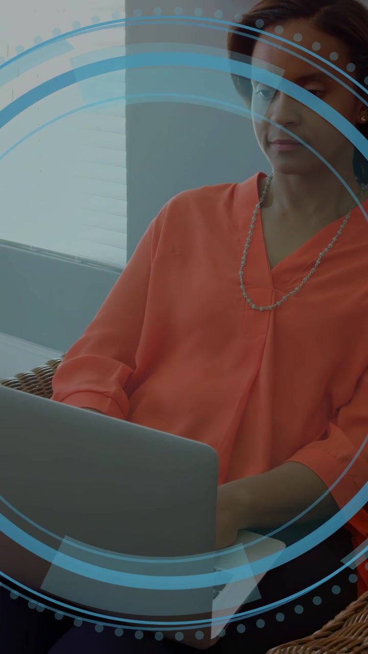 Vertikal video: Kvinde taster på bærbar computer, igangsætter et ekspanderende cirkulært teknologi-overlay til analyse