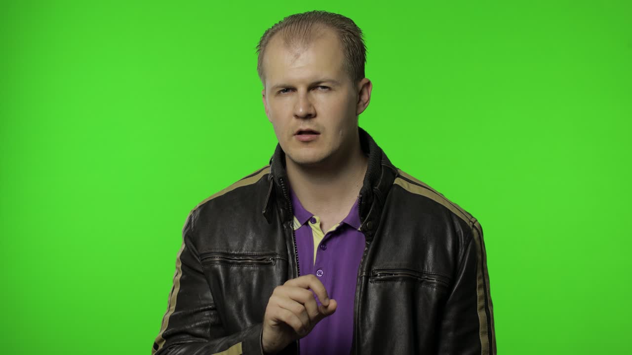 shh, no digas el secreto. rocker hombre en chaqueta marrón poniendo el dedo en los labios haciendo el gesto del silencio