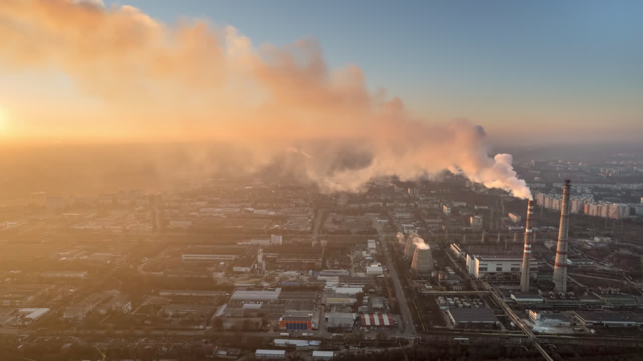 Aerial drone timelapse view of thermal power plant in Chisinau at sunset, Moldova. View of pipes with felling steam, cityscape