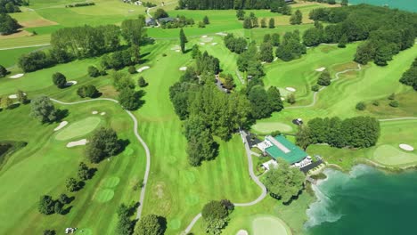 Cautivadoras-Imágenes-Tomadas-Con-Drones-De-Un-Campo-De-Golf-Austriaco,-Ubicado-Junto-A-Las-Aguas-Color-Esmeralda-Del-Lago-Mondsee.