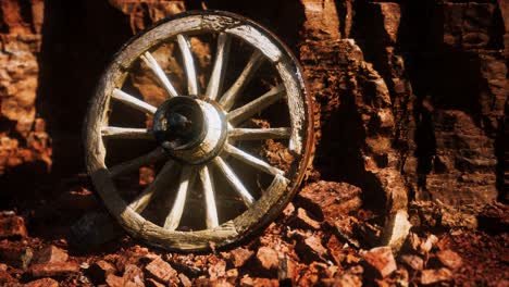 old wooden cart wheel on stone rocks