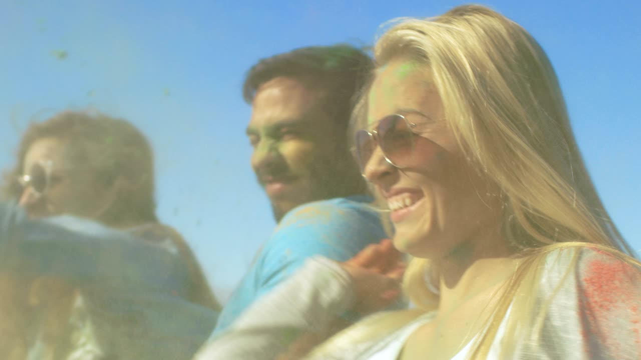 Multi-Ethnic Group of Young People Throw Colorful Powder at Each other in Celebration of Holi Festival. They Have Enormous Fun on this Clear Day by the Sea.