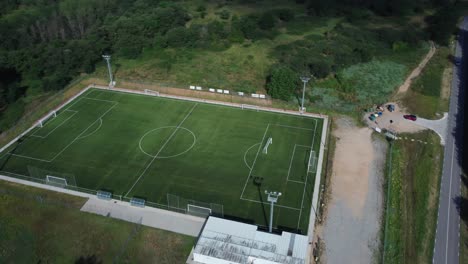 Campo-De-Fútbol-Verde-En-Medio-De-Montañas,-Vista-Aérea-4k