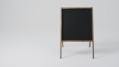 video de un letrero de pizarra en un soporte de madera con espacio de copia en un fondo blanco