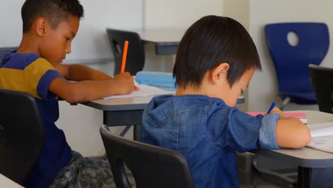 multi-ethnic schoolkids studying at desk in a classroom at school 4k