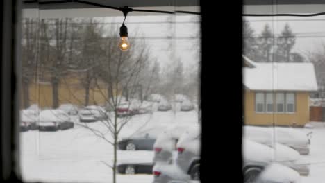 Trucking-slider-shot-of-snowy-neighborhood-with-snow-covered-roads-and-cars