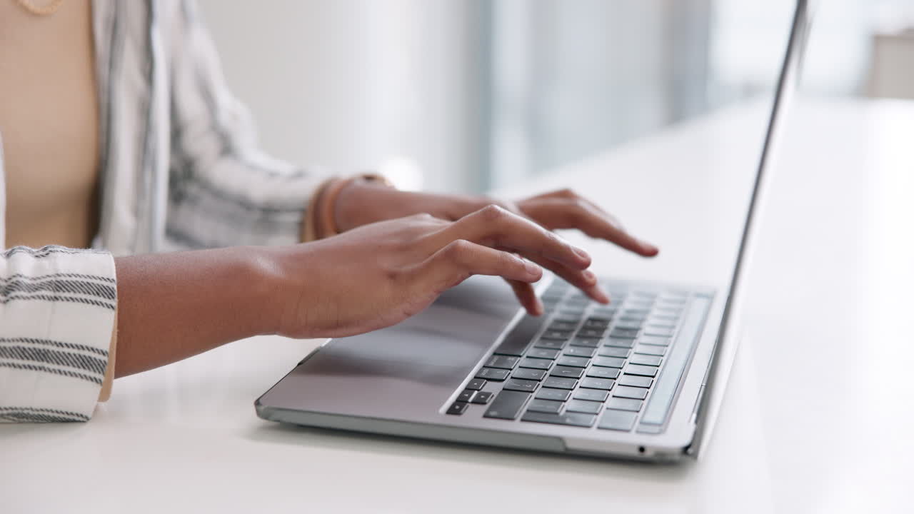 Hands typing on a laptop