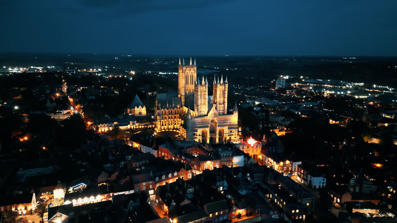 공중 드론 비디오는 영국의 링컨셔에 있는 유명한 링컨 대성당을 어두워지면서 촬영하고 있으며, 그 웅장한 고 ⁇  건축을 조명으로 보여줍니다.
