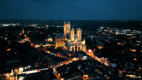 un video de un dron aéreo captura la famosa catedral de lincoln en lincolnshire, reino unido, al anochecer, mostrando su majestuosa arquitectura gótica con iluminación