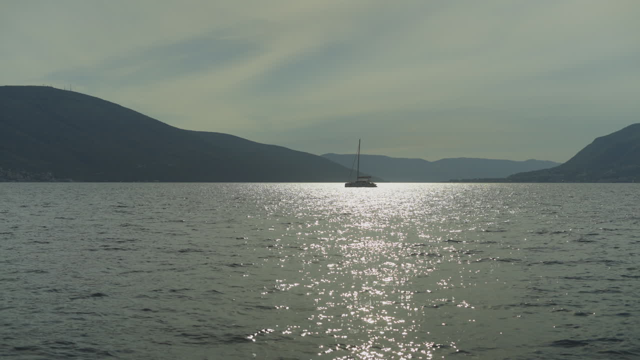 해가 지는 동안 평온 한 만 에 있는 항해 보트