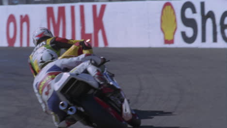 two motorcyclist race around a track