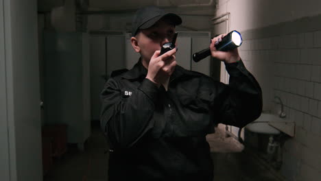 guardia de seguridad femenina con linterna en un almacén
