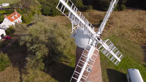 molino de viento de billingford en un área de campo de granja con casa en diss, norfolk - disparo de seguimiento de vuelo de drones aéreos