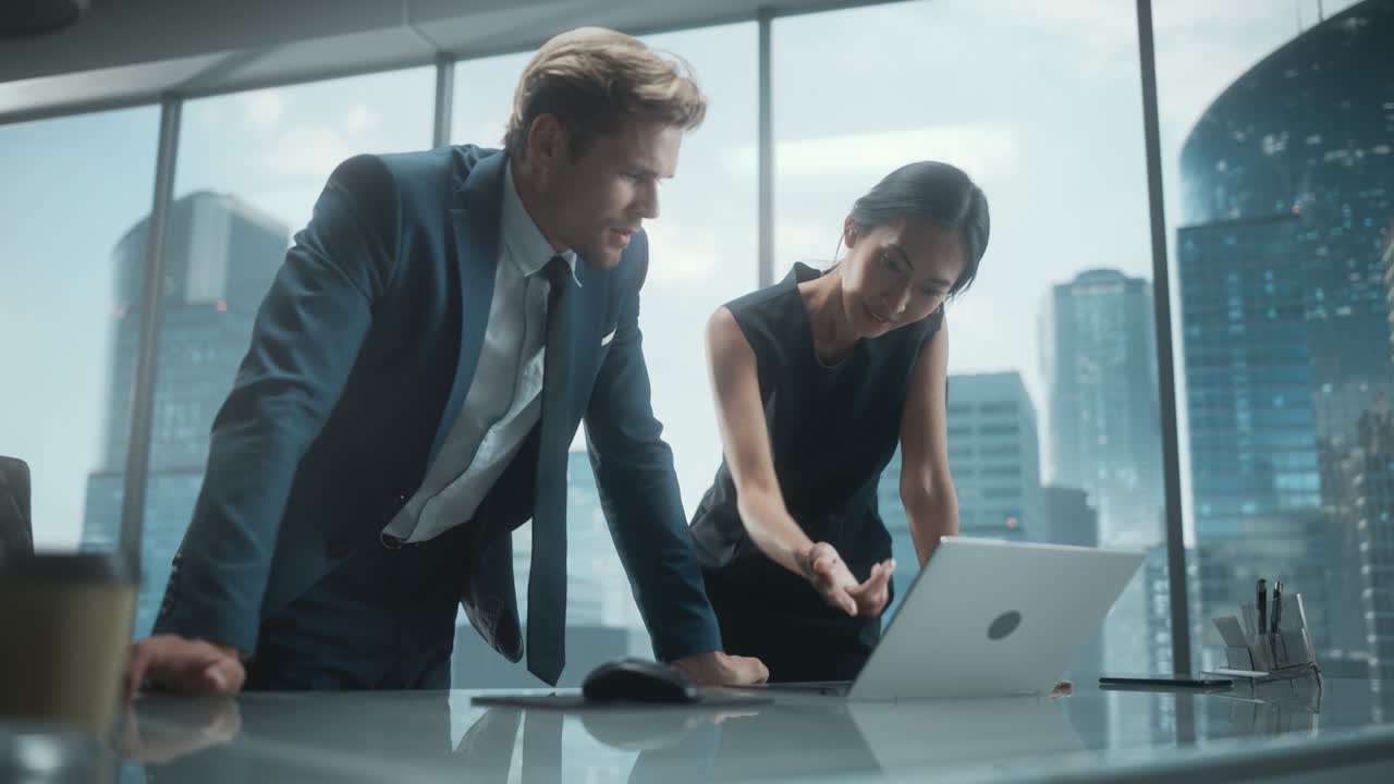 Portrait of Successful Corporate CEO and Finance Manager Talking, Using Laptop Computer while Standing in City Office. Stock Market Investors Negotiate e-Commerce Business Purchase.