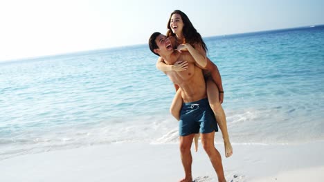 hombre dando paseo a caballo a la mujer en la playa