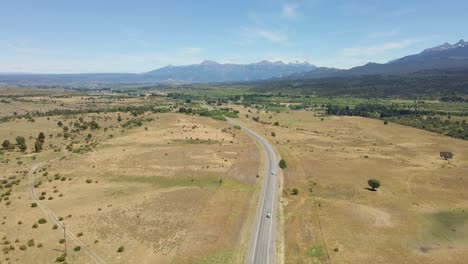 muñeca aérea siguiendo un camino rural solitario con montañas de fondo durante el día