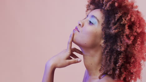 femme biraciale aux cheveux noirs en lumière bleue et rose avec espace de copie, au ralenti