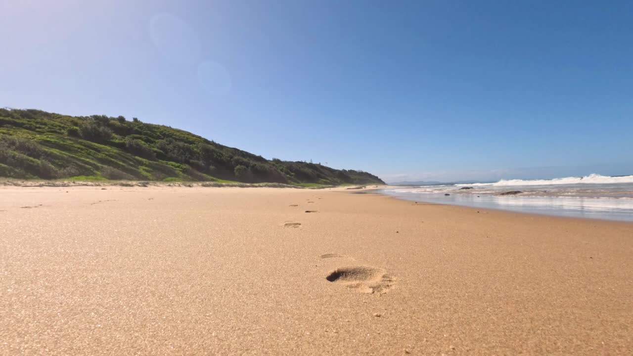 바다의 파도와 함께 모래 해변에 발자국