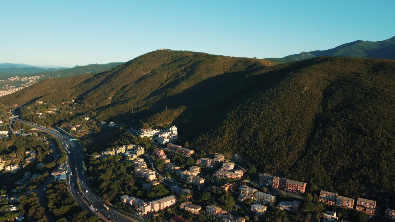 ciudad costera italiana con autopista y montañas