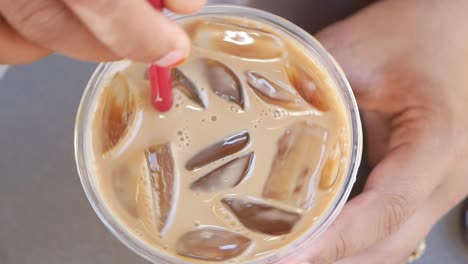 woman holding a cup of iced coffee