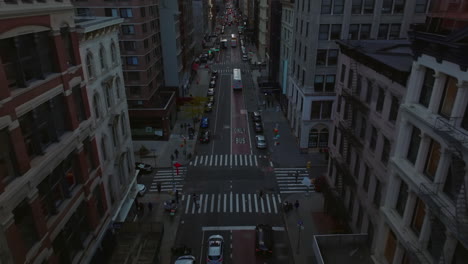 High-angle-view-of-downtown-street.-Forwards-fly-above-cars-and-buses-waiting-at-traffic-lights.-Manhattan,-New-York-City,-USA