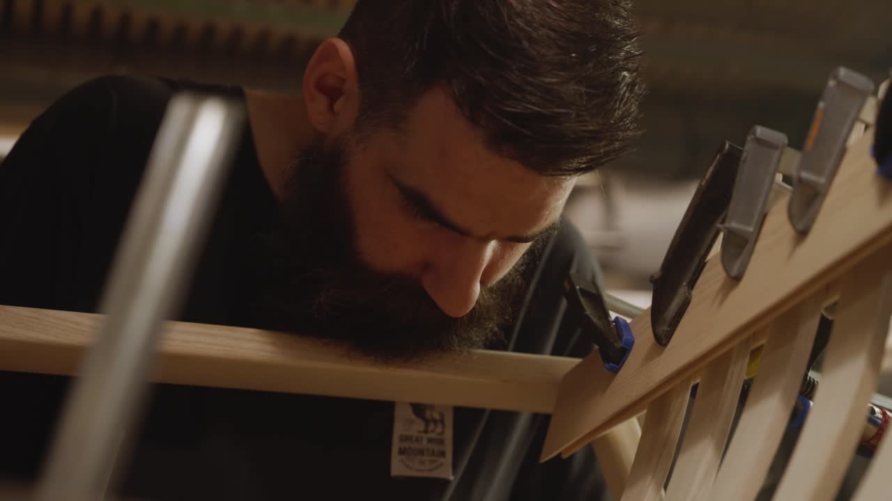 Close-up view of a craftsman precisely measuring a wooden frame using a ruler and pencil, highlighting woodworking accuracy, craftsmanship, and attention to detail in furniture making