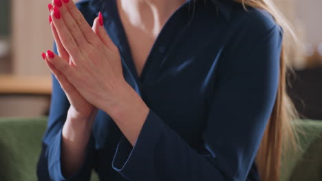facilitator gestures with manicured nails over notebook beside colorful pencils and clock during therapy session in bright cozy room, focus on confident hand movements and professional attire