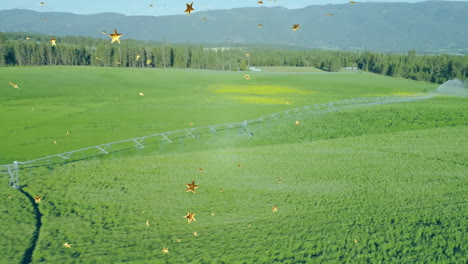 pivot irrigation pipe crossing field diagonally, sprinklers spraying water and sparkles