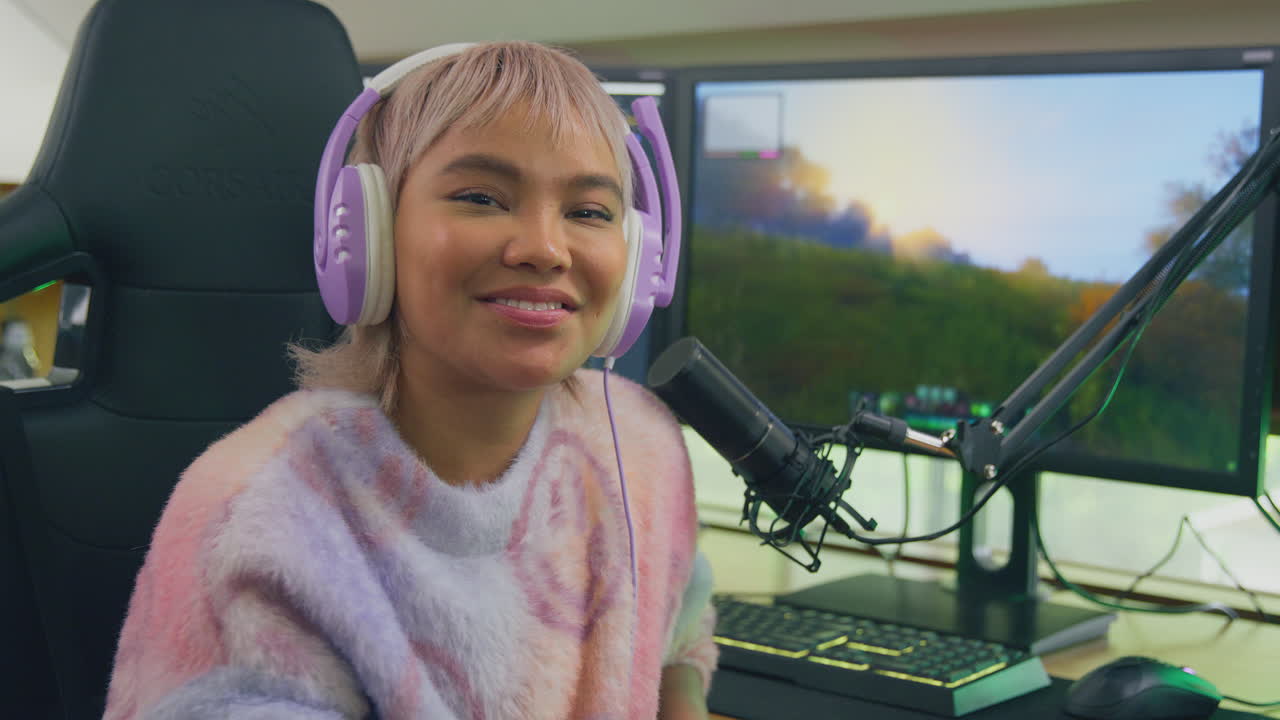 retrato de una mujer jugando en casa sentada en un escritorio con auriculares para transmisión en vivo