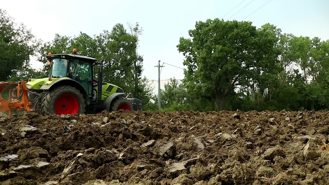 tractor pesado pasa y ara la tierra recién cosechada