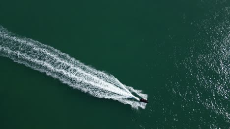 top down aerial tracking shot of single jet ski in ocean