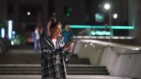 woman using phone at night in city