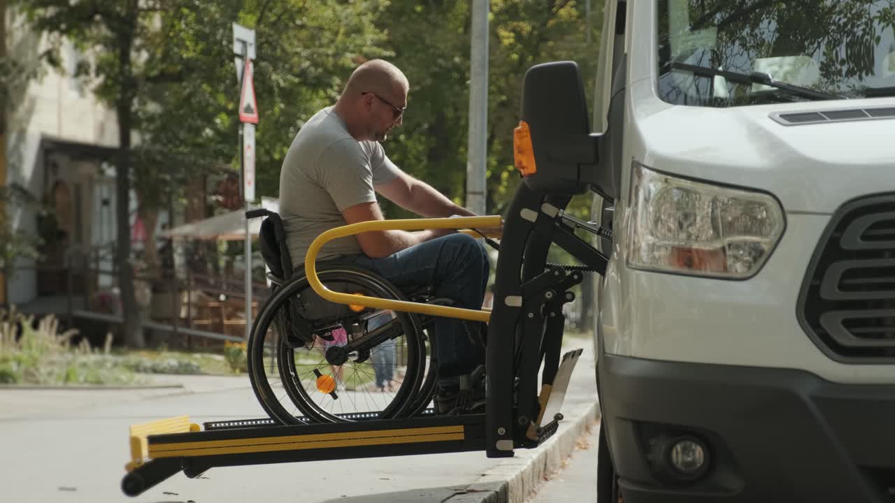 A man in a wheelchair on a lift of a vehicle for people with disabilities. Lifting equipment for people with disabilities - man in wheelchair near the vehicle