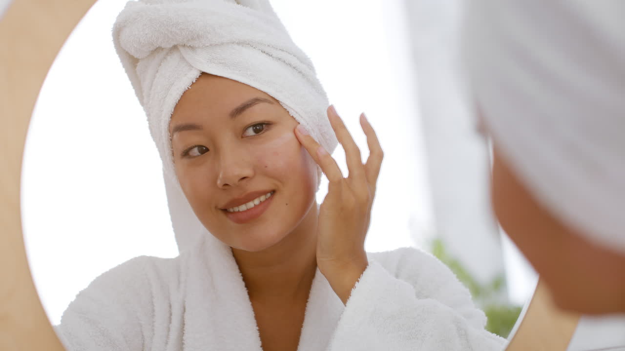 거울 앞 에서 피부 관리 를 하는 여자