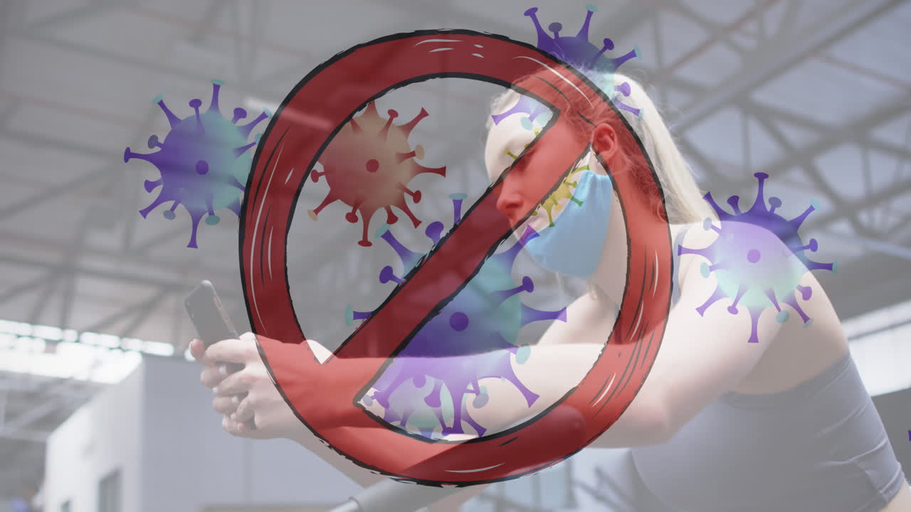 체육관에서 스마트폰을 사용하는 백인 여성을 상대로 움직이는 코로나19 세포를 중단하십시오.