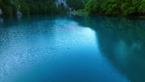 pullback over man walking on trails in plitvice lakes national park during sunrise in croatia