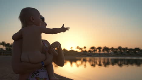 relaxed mother and cute boy having fun of beautiful sunset on resort beach.